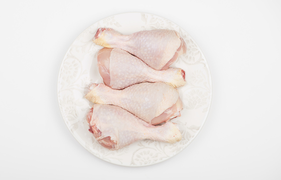 Top view of pile of raw chicken thighs isolated on dish. / This content is subject to copyright., Freestocker Top view of pile of raw chicken thighs isolated on dish.